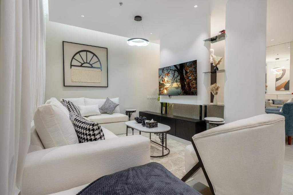a living room with two white chairs and a couch at رواء آن للضيافة in Quai