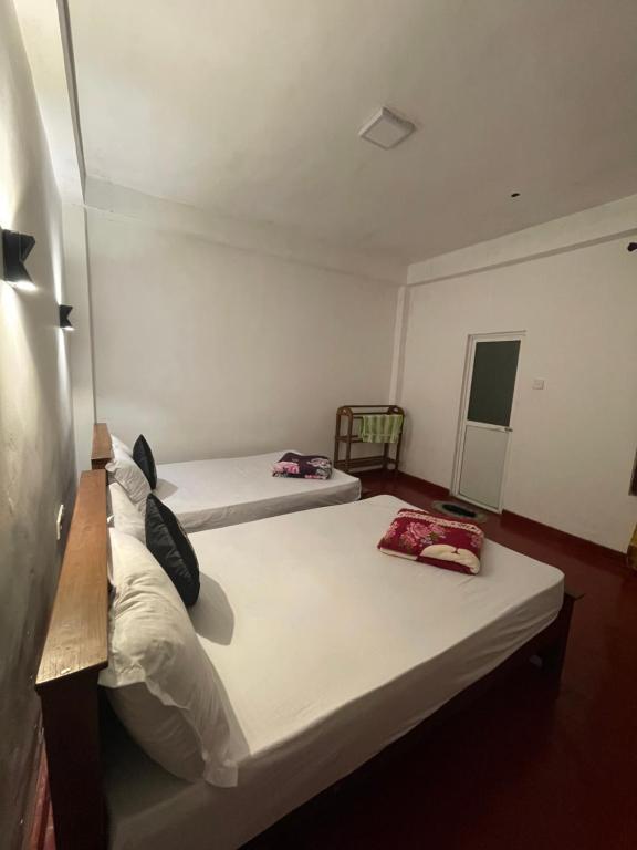 two beds in a small room withthritisthritis at saffronvilla in Haputale