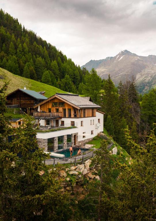 a house on a hill with people in front of it at Leni Mountain Chalet in Sölden