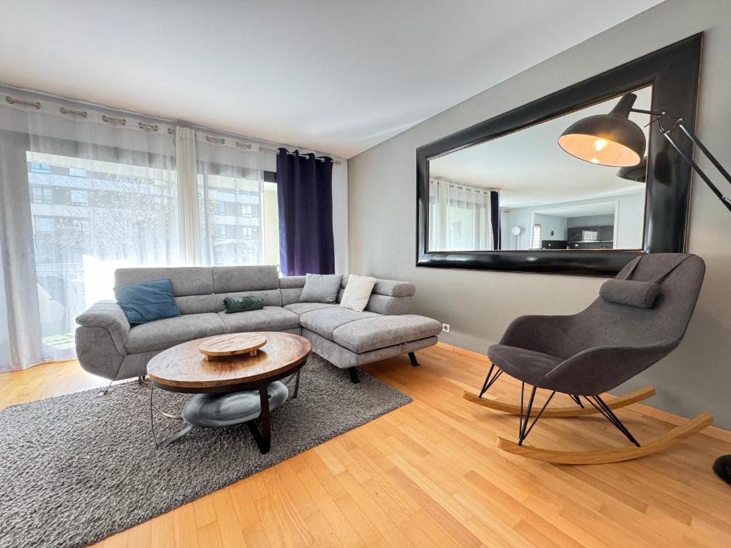 a living room with a couch and a table and a mirror at Big Flat - Direct CERN in Saint-Genis-Pouilly