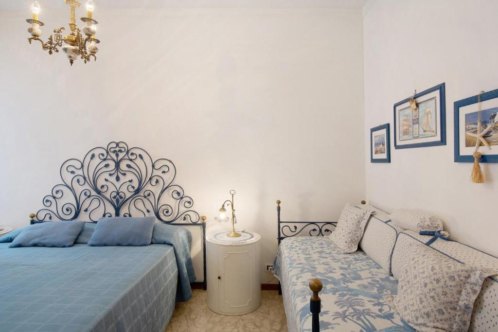 a bedroom with two beds and a chandelier at Zaffiro Apartment With Garage in Rapallo