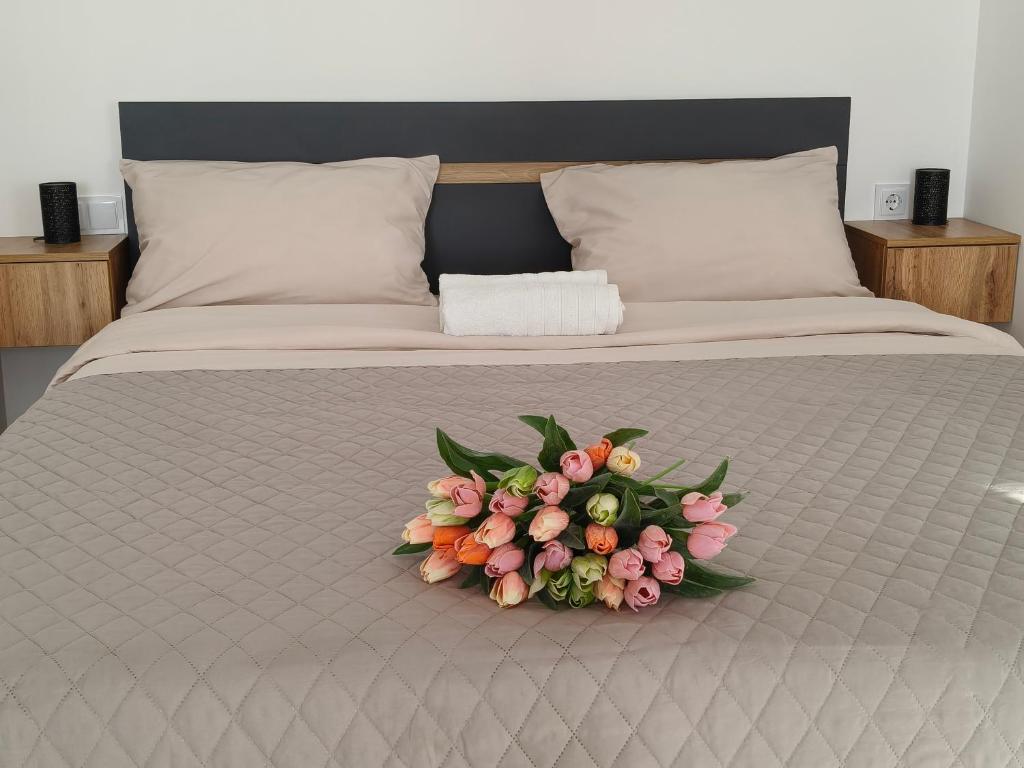 a bed with a bouquet of flowers on it at Comfort House Партизанська 25 in Bila Tserkva