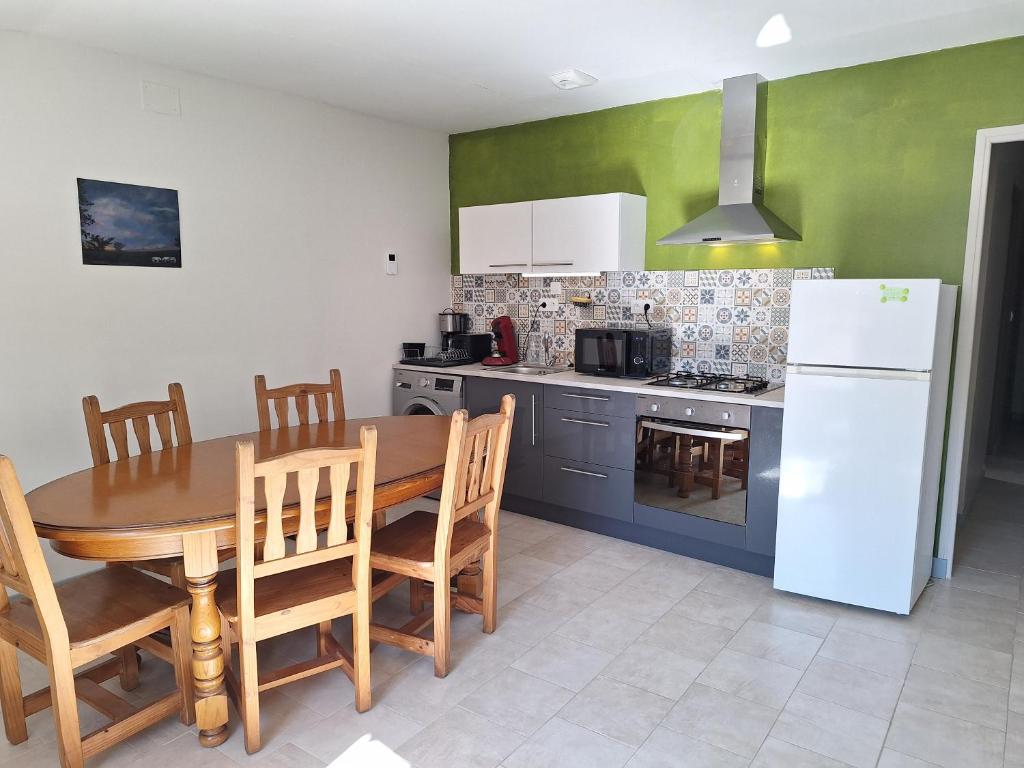 a kitchen with a wooden table and a white refrigerator at Chez René in Montagnac