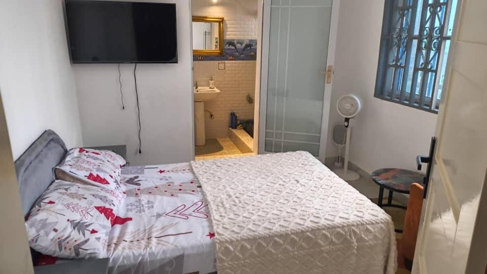 a bedroom with a bed and a flat screen tv at Ivan John Guest home in Number Two Village