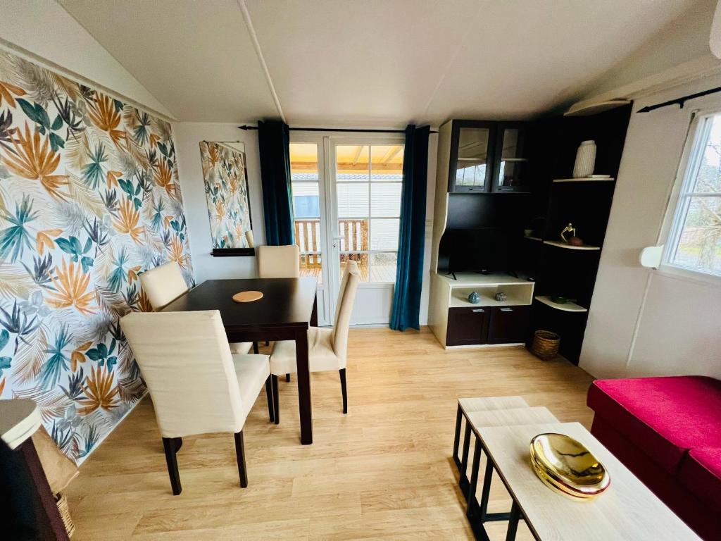 a living room with a table and chairs and a couch at MH J08 - Camping Siblu La plage in Mimizan-Plage