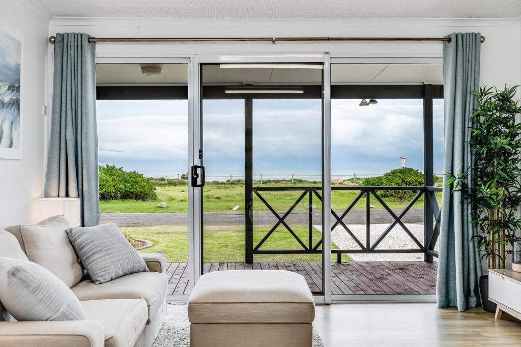 a living room with a couch and a sliding glass door at Adrift - Oceanfront - Pets Welcome in Middleton