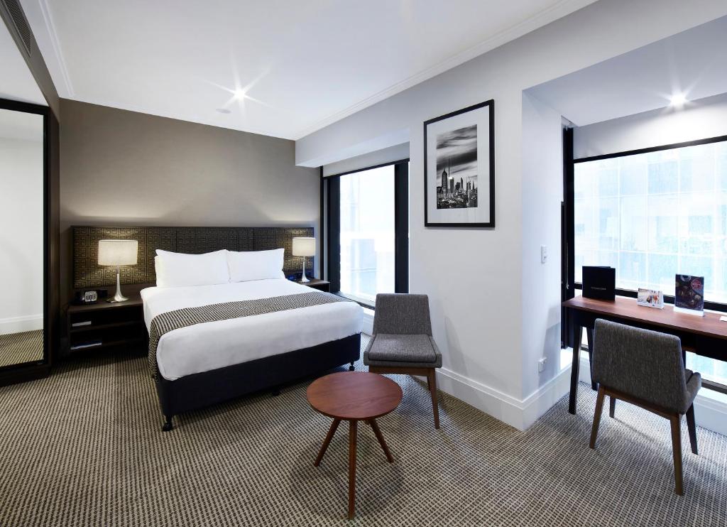 
a hotel room with a bed and a desk at Stamford Plaza Melbourne in Melbourne
