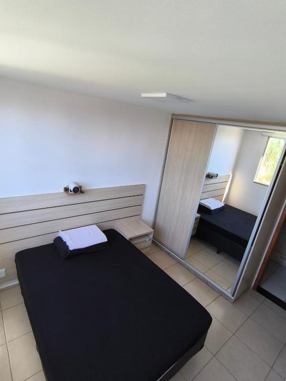a room with a mirror and a bed in it at Apartamento 1Q 2B com vaga in Aparecida de Goiânia
