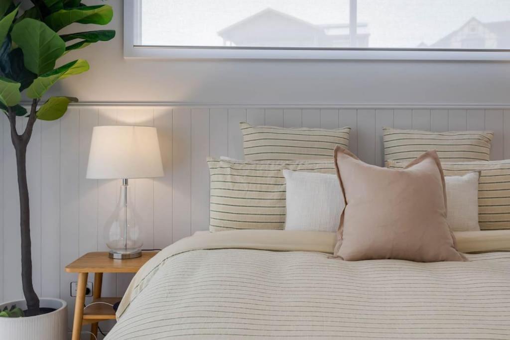 a white bed with white pillows and a window at Allawah in Encounter Bay