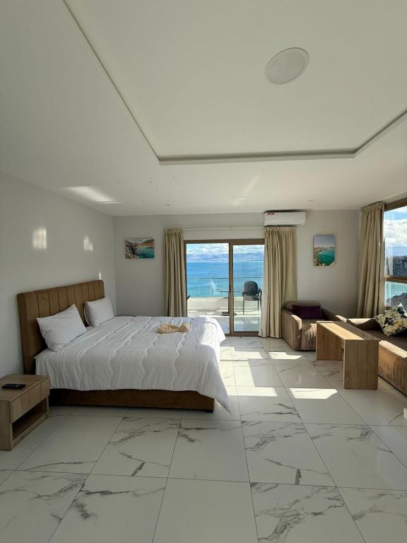 a bedroom with a bed and a view of the ocean at Golden Bay Hotel in Al Hoceïma