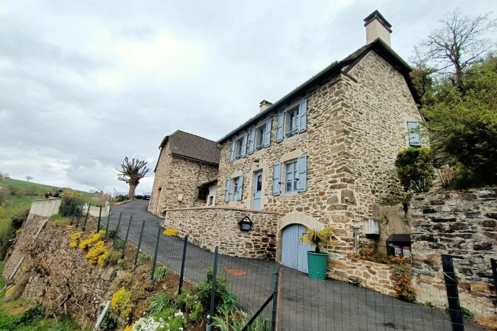 a stone building with a fence in front of it at La bellevue in Lapeyrugue