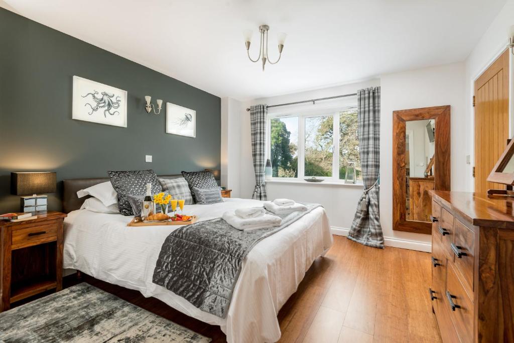 a bedroom with a bed with a tray of food on it at Heather Barn in Saltash