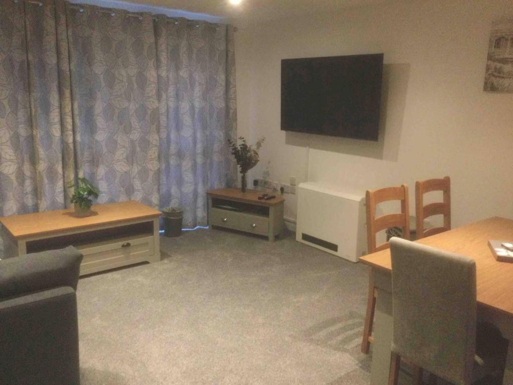 a living room with two tables and a television on the wall at Gorgeous Marina 2 Bed Apartment in Portishead