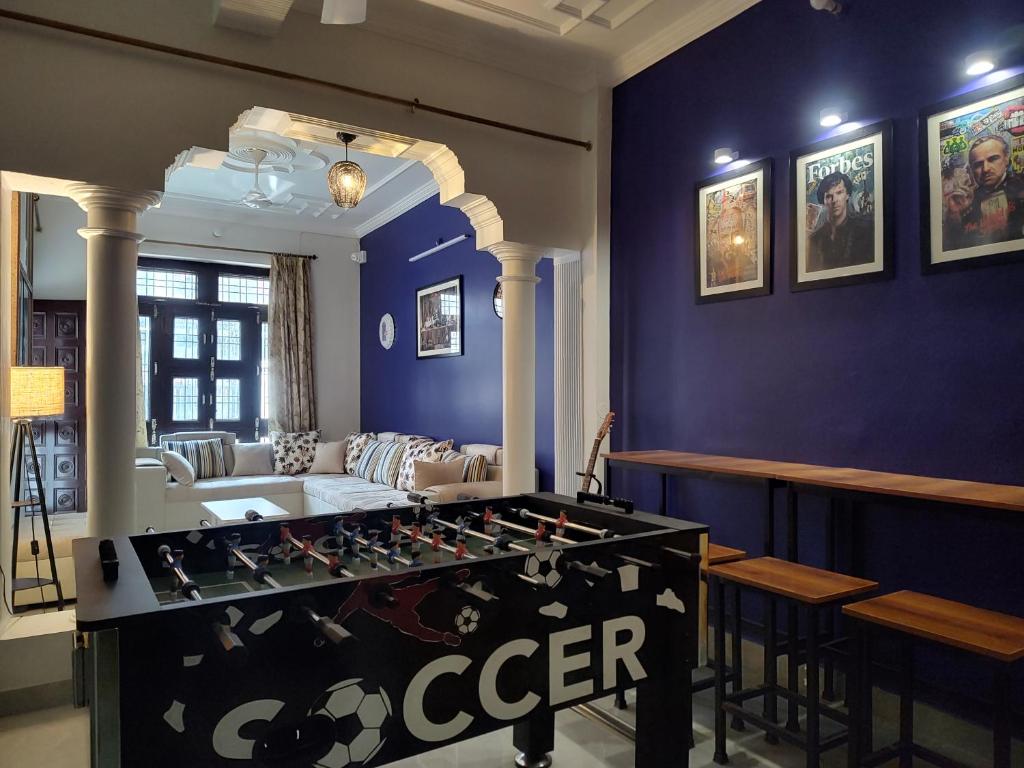 a room with a foosball table in the middle of a living room at Bed N Banter - Lucknow in Lucknow