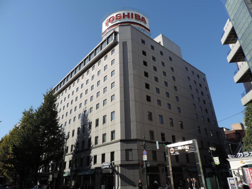 Biały budynek z czerwonym znakiem na górze w obiekcie Hotel Grand Terrace Sendai Kokubun-cho w mieście Sendai