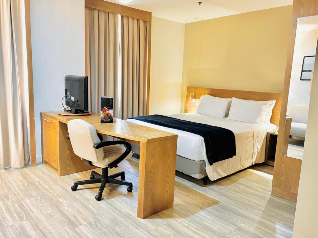a hotel room with a bed and a desk with a computer at AV Paulista - SP - Centro in São Paulo