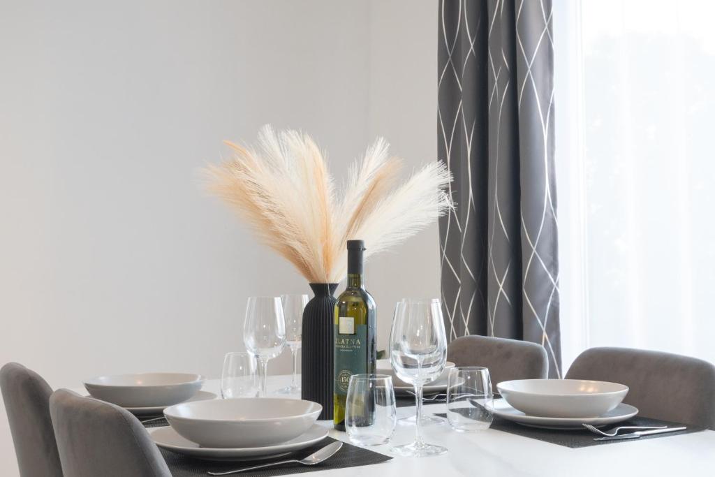 a dining room table with a bottle of wine and glasses at Apartman Turcic in Malinska