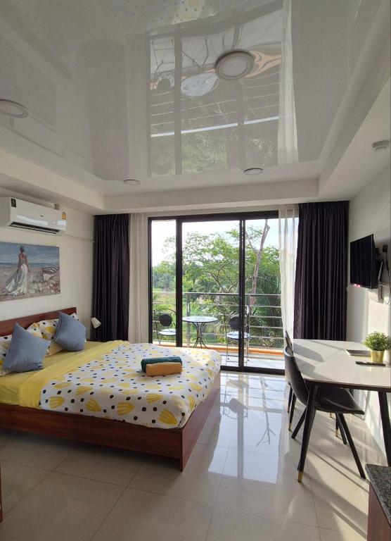 a bedroom with a bed and a table and a desk at PB326 Beautiful studio in Phuket in Ban Mai Salae