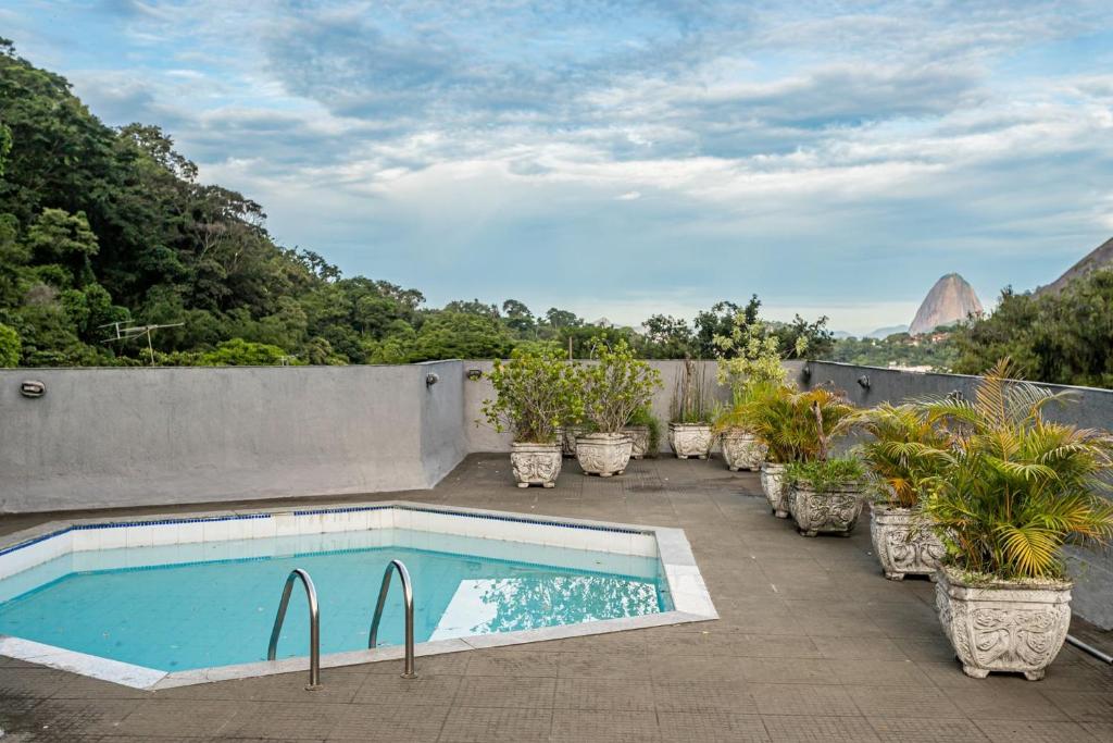 a swimming pool on the roof of a house with potted plants at Rio´s Mansion: Sugar Loaf, The Redeemer and Pool in Rio de Janeiro