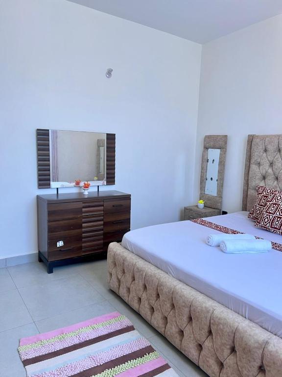 a bedroom with a large bed and a mirror at DIANI 2 Bed STUDIO in Gatunga
