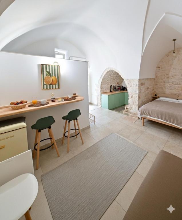 a room with a bed and a table and chairs at Almurigini I Boutique House I Ceglie Messapica in Ceglie Messapica