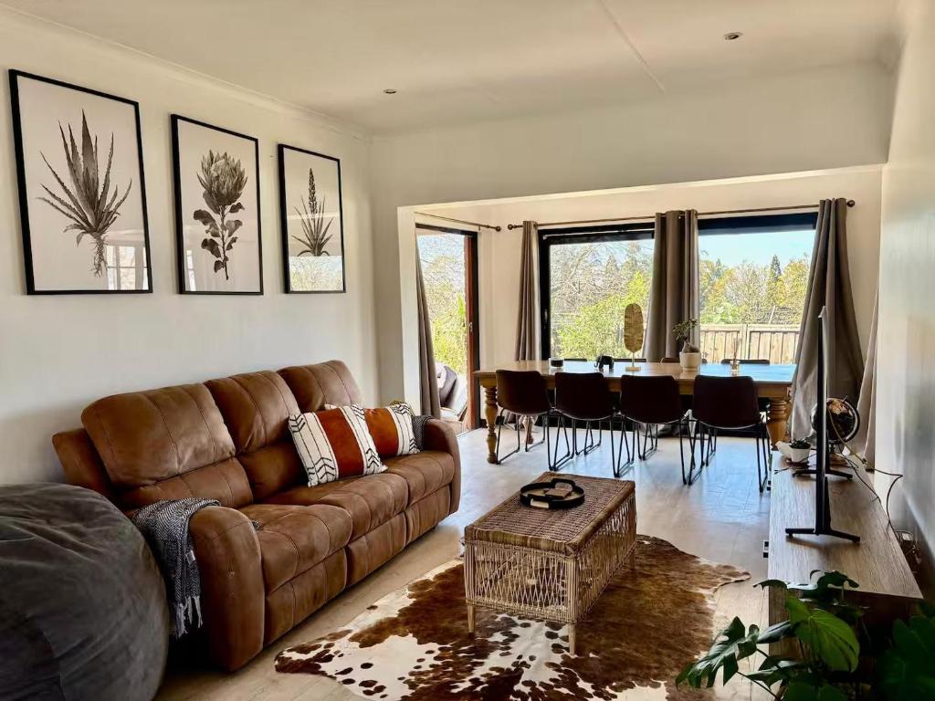 a living room with a brown couch and a table at 4 Laddswood Lodge in Hilton