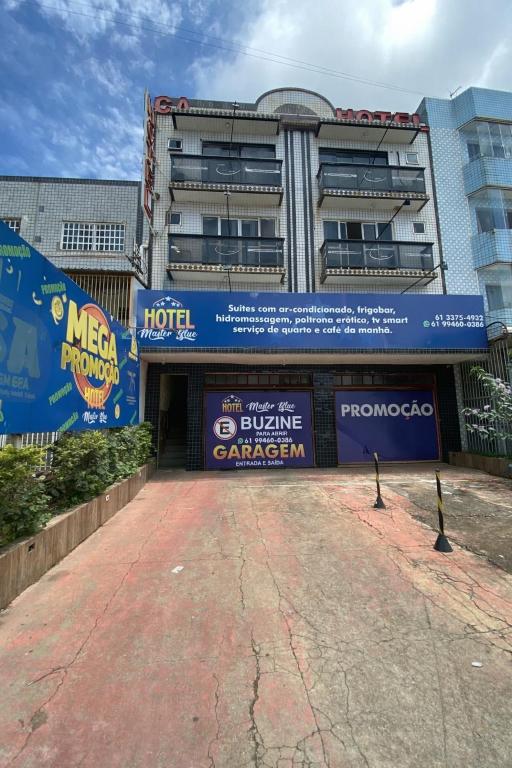 a building with a parking lot in front of it at Hotel Master Blue - Brasília in Ceilândia