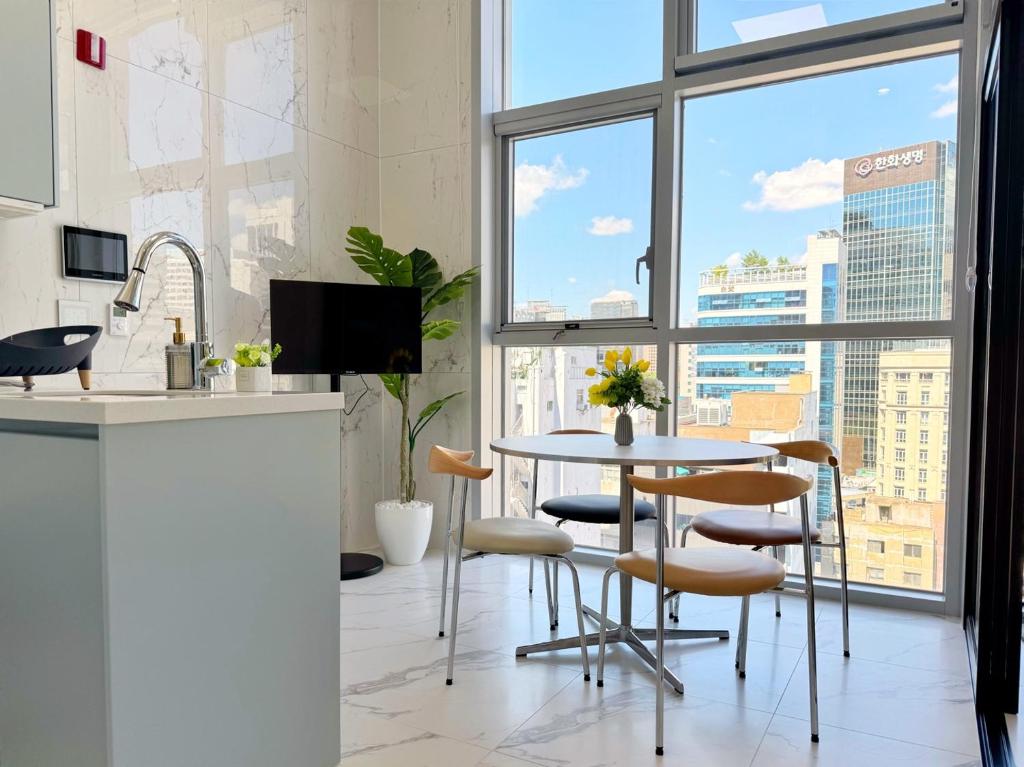 a kitchen with a table and chairs and a large window at The Comfort in Seoul