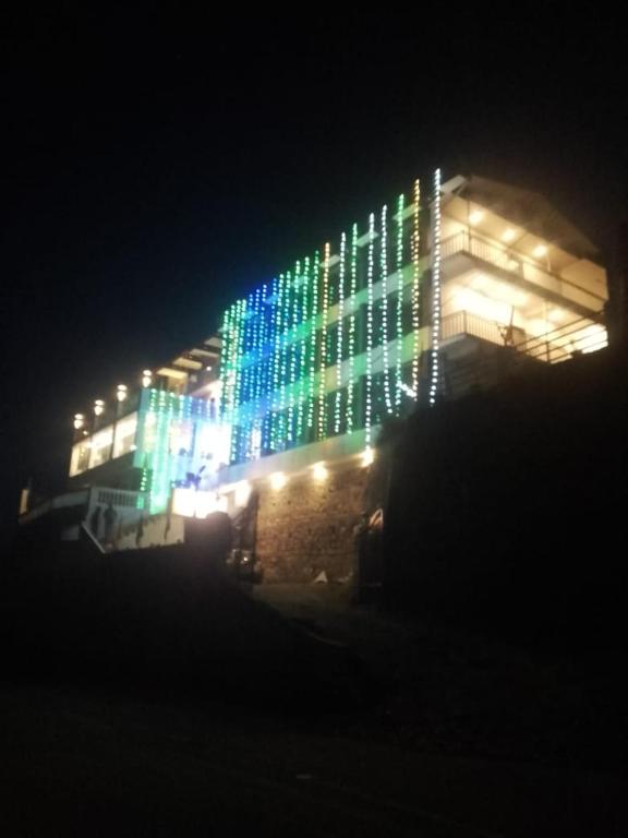 a lit up building with blue and green lights at Valley View in Dhanaulti