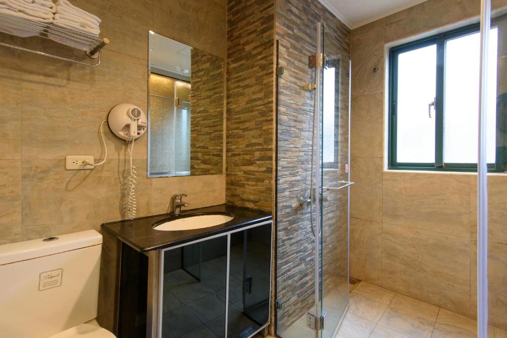 a bathroom with a sink and a shower at Harbor Elite Hotel in Yuchi