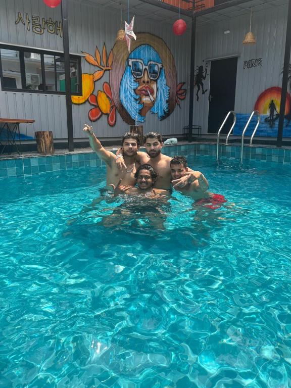 a group of men standing in a swimming pool at Half Orange in Vagator