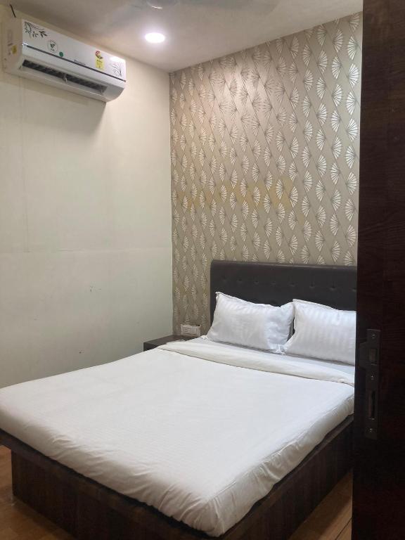 a bedroom with a large bed with white sheets at Hotel Grants Residency Colaba in Mumbai