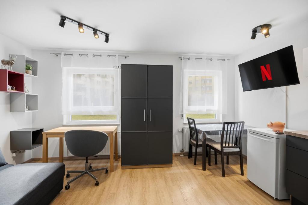 a bedroom with a desk and a table with a chair at Moderne Einraumwohnung in Leipzig mit Netflix Zugang in Leipzig