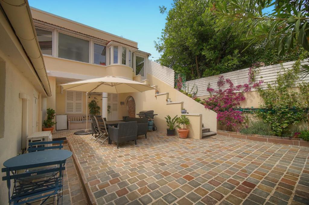a house with a patio with a table and an umbrella at FRGK "4 Suites Privées Exclusives" in Cannes