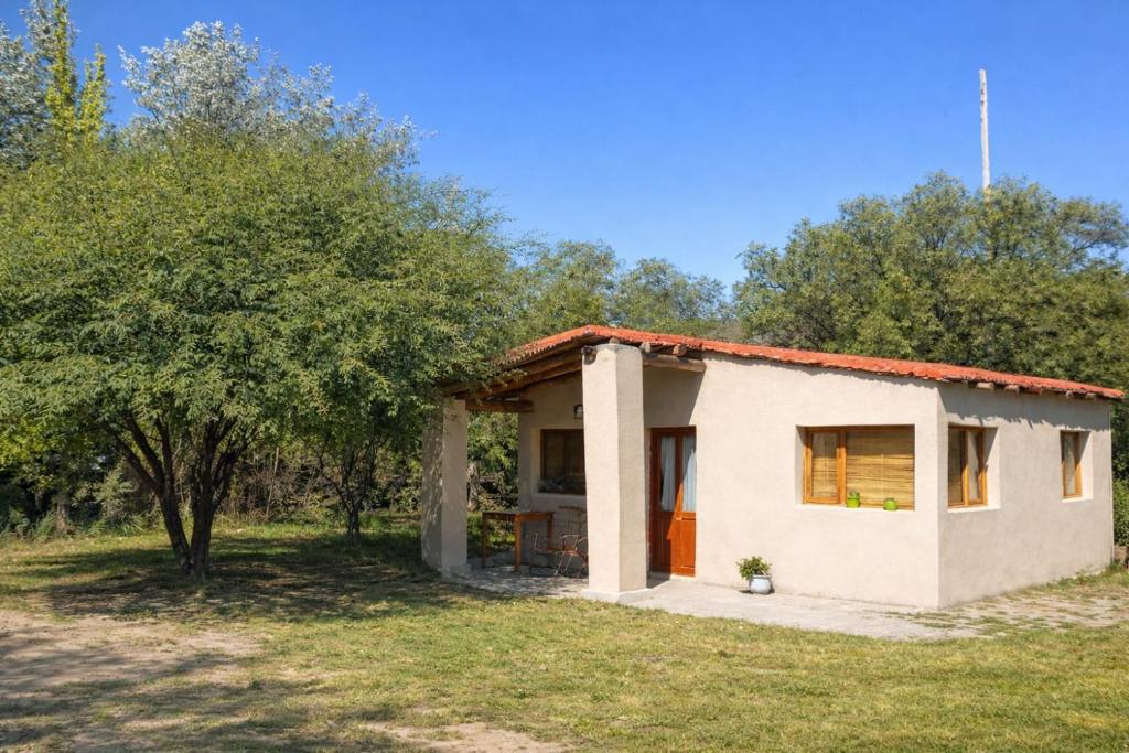 a small house in a field with a tree at El Sueñero Tilcara in Tilcara