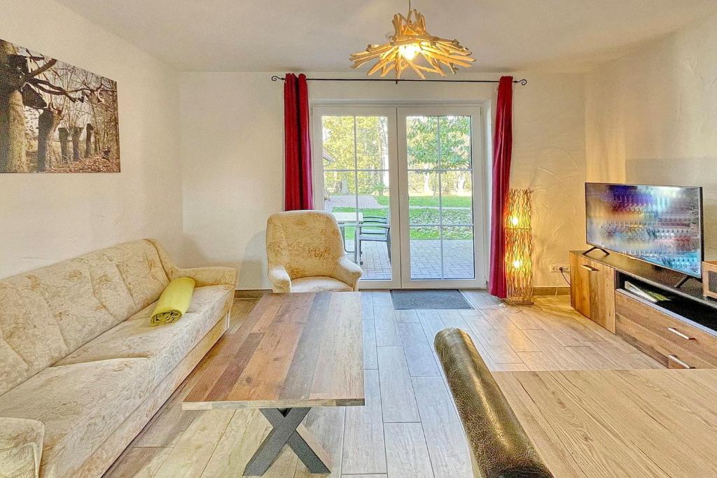 a living room with a couch and a tv at Blockhaus Baum 3 in Burg