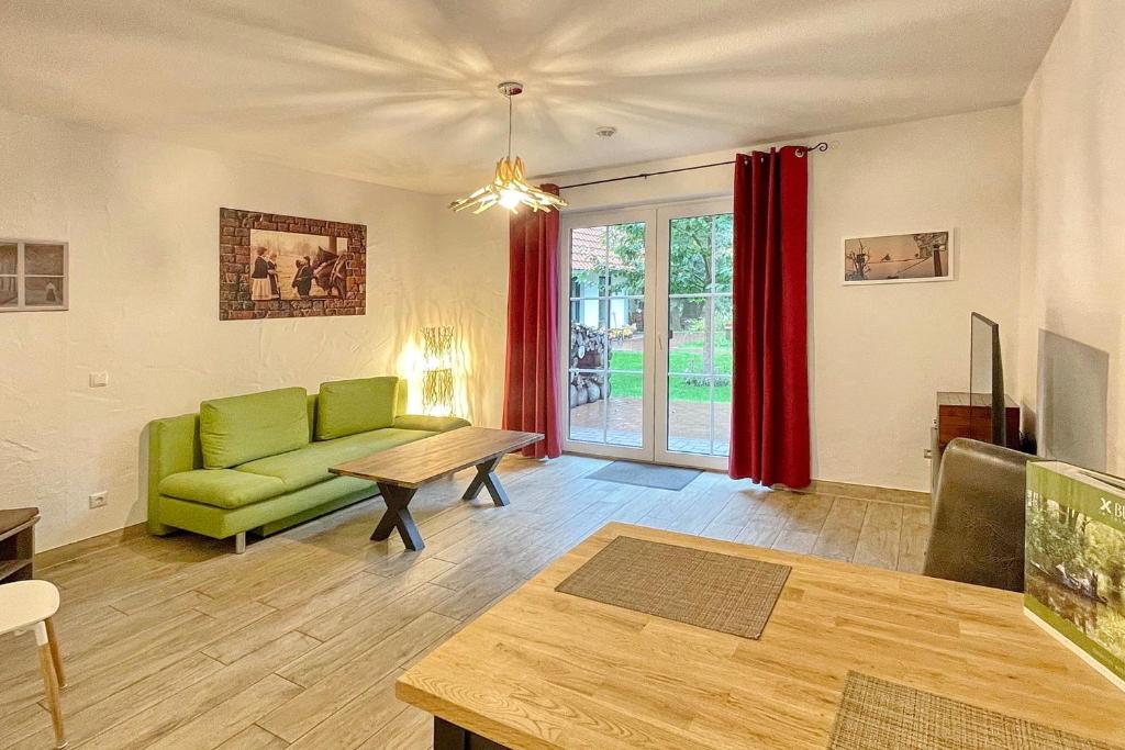 a living room with a green couch and a table at Holzfäller Baum 2 in Burg