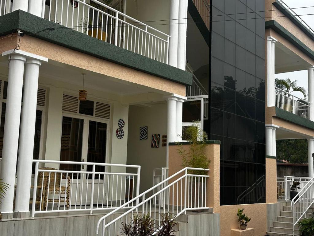 a white house with white railings and a building at ADRIEL HOMES KIGALi in Kigali