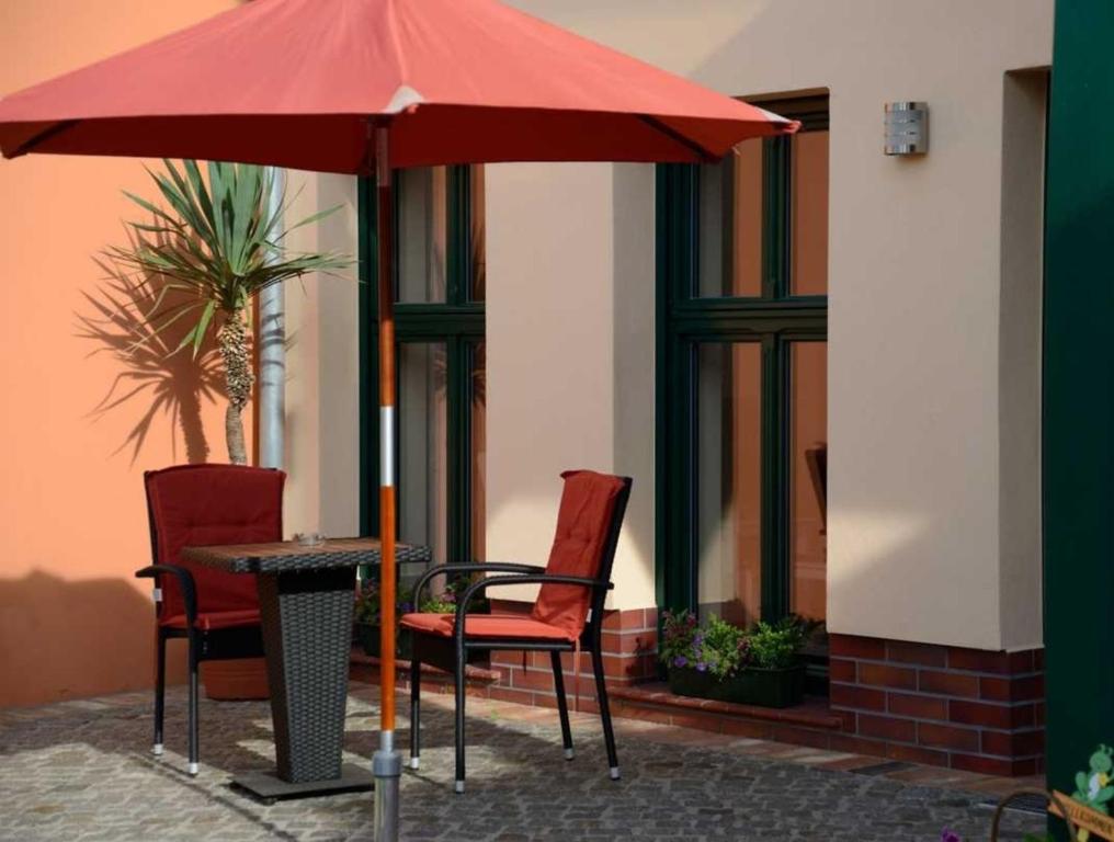 a table and chairs under an umbrella on a patio at Malz in Lübbenau