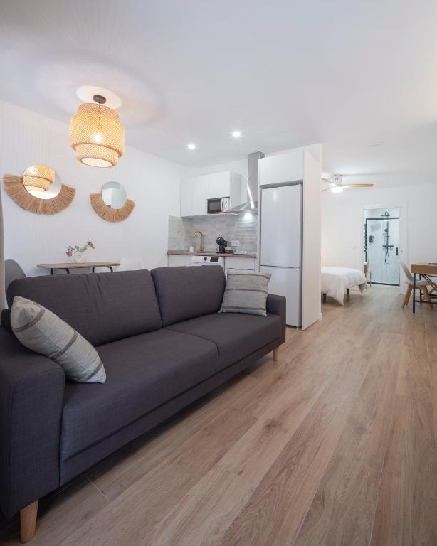a living room with a couch and a kitchen at Apartamento Donoso Cortés in Badajoz