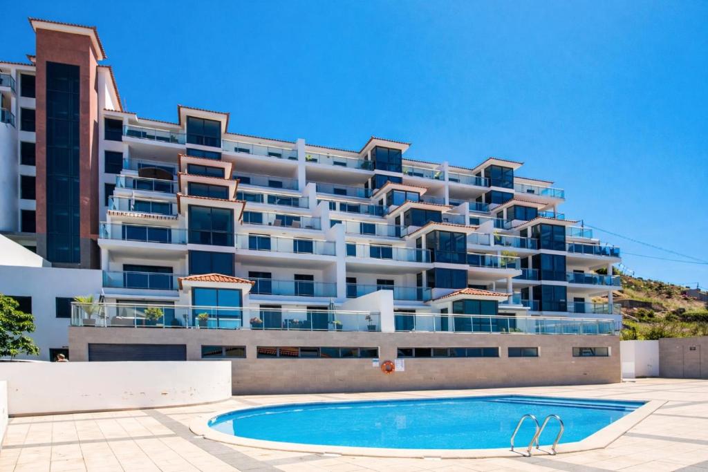 a large building with a swimming pool in front of it at Paradisus guest house in Caniço