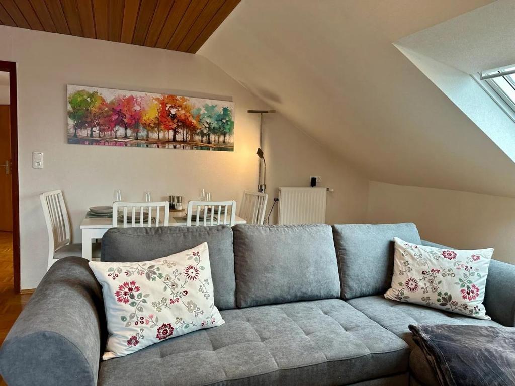 ein Wohnzimmer mit einem blauen Sofa und einem Tisch in der Unterkunft Schlierbachblick in Eschwege