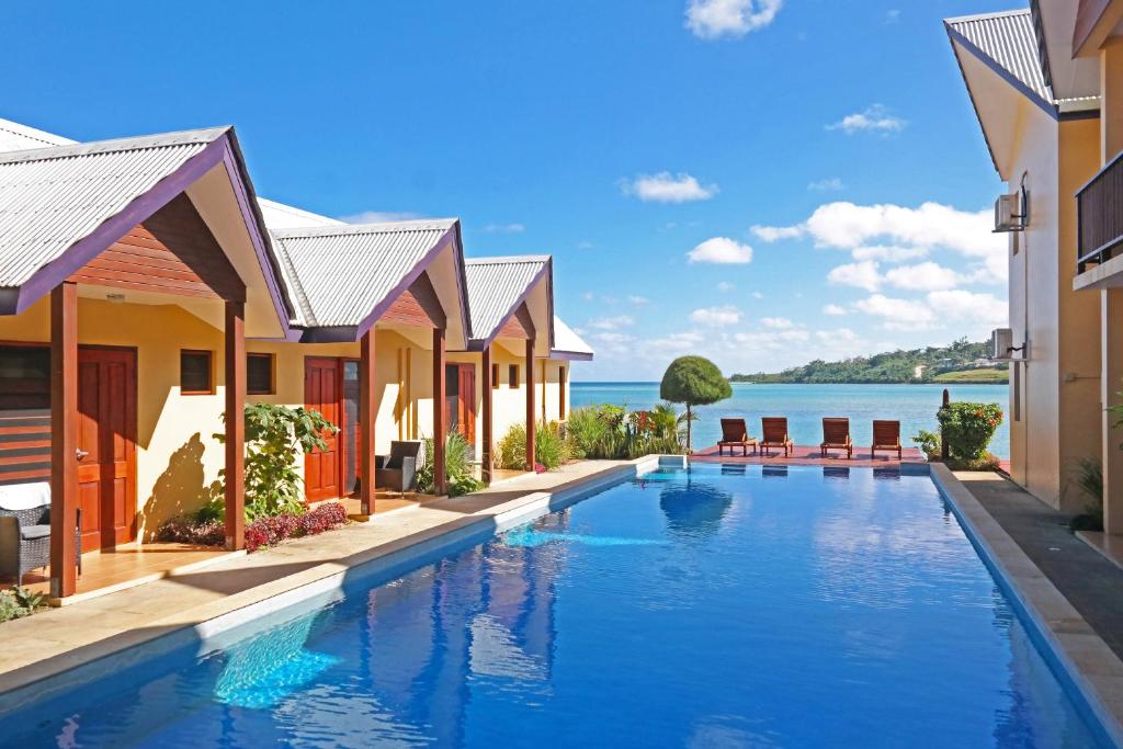 a resort swimming pool with a view of the water at Moorings Hotel in Port Vila