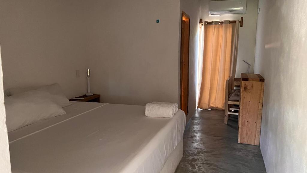 a bedroom with a large white bed in a room at Casa Momo Playa Zipolite Oaxaca in Zipolite