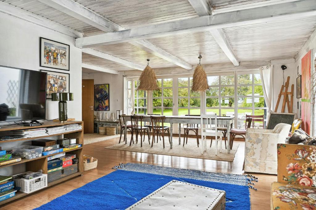 a living room with a dining room table and chairs at By The Bay A Thatched House Lies So Beautifully in Nørre Åby