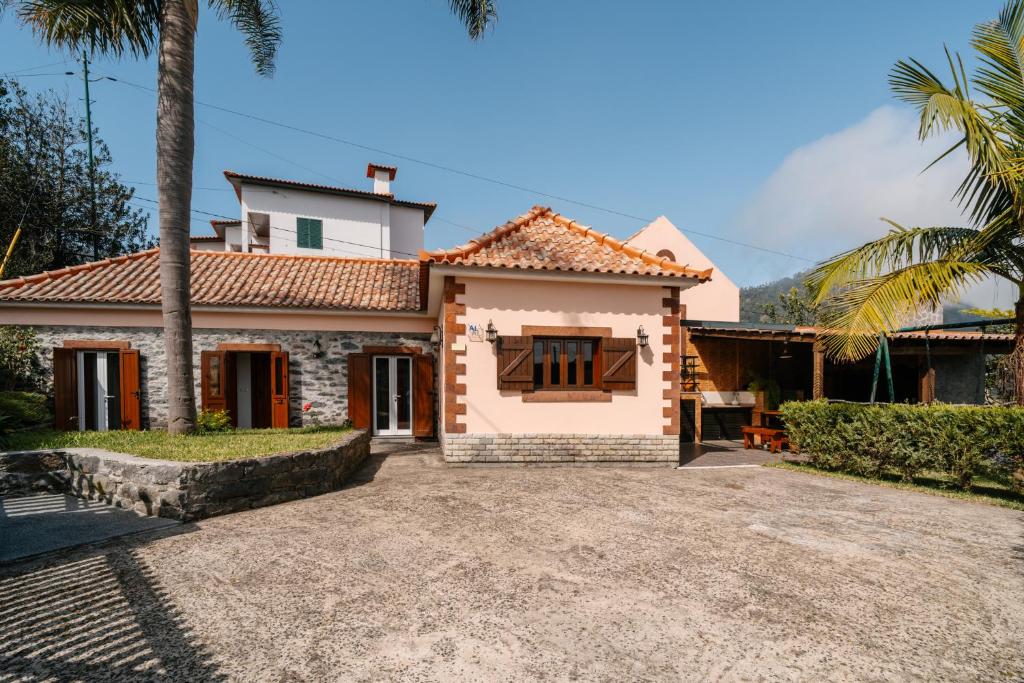 a house with a palm tree and a driveway at Casa do Faial in Santana
