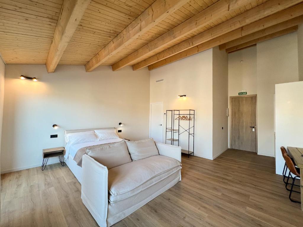 a living room with a white couch and wooden ceilings at Salon Suites in Tremp
