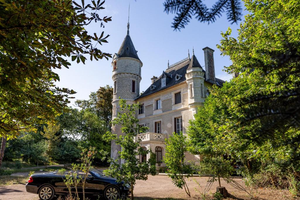a black car parked in front of a castle at château de Puymoger in Javerlhac-et-la-Chapelle-Saint-Robert
