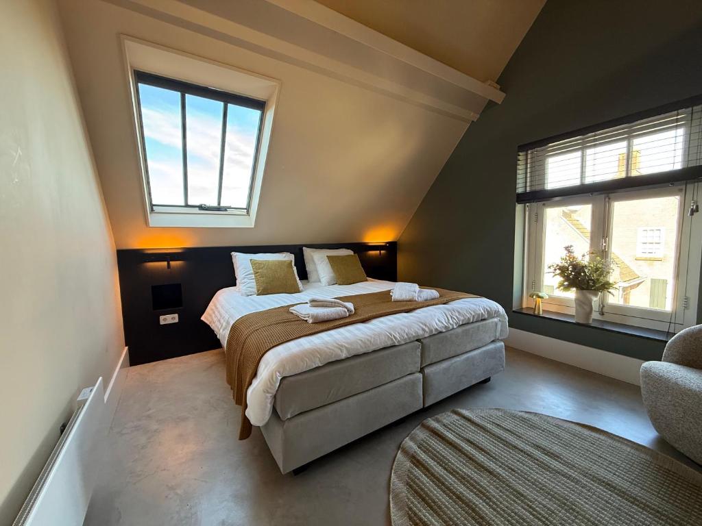 a bedroom with a bed and two windows at B&B Louwi in Breugel