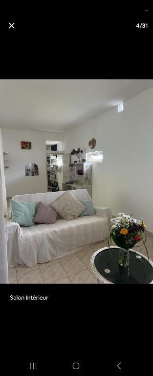a living room with a white couch and a table at Naturelle Évasion in Grand-Baie